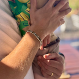 Dad holding young boy wearing bracelets