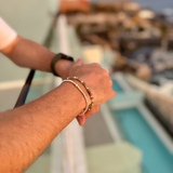 Man's hands overlooking luxury hotel balcony wearing bracelets