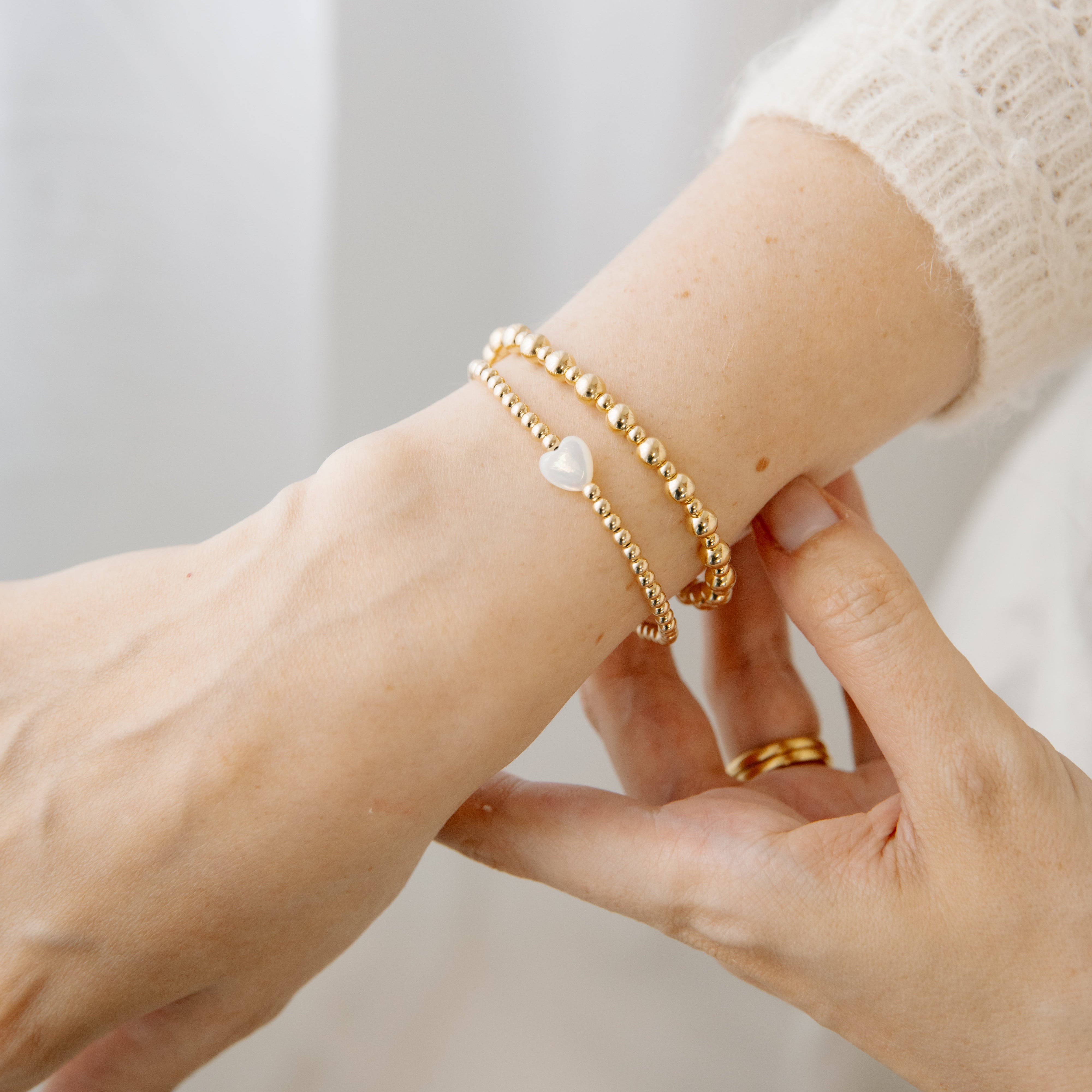Gold beaded bracelet and a heart bracelet