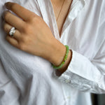 woman wearing white shirt with green bead bracelet 