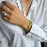 woman wearing white shirt with green bead bracelet 