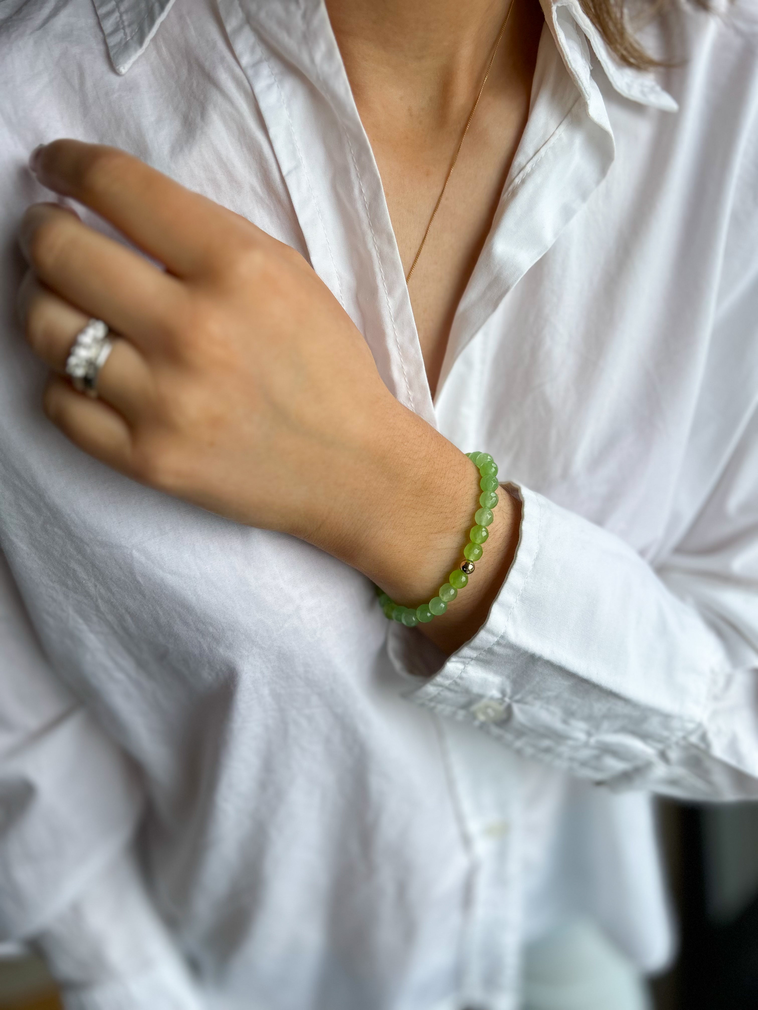 woman wearing white shirt with green bead bracelet 