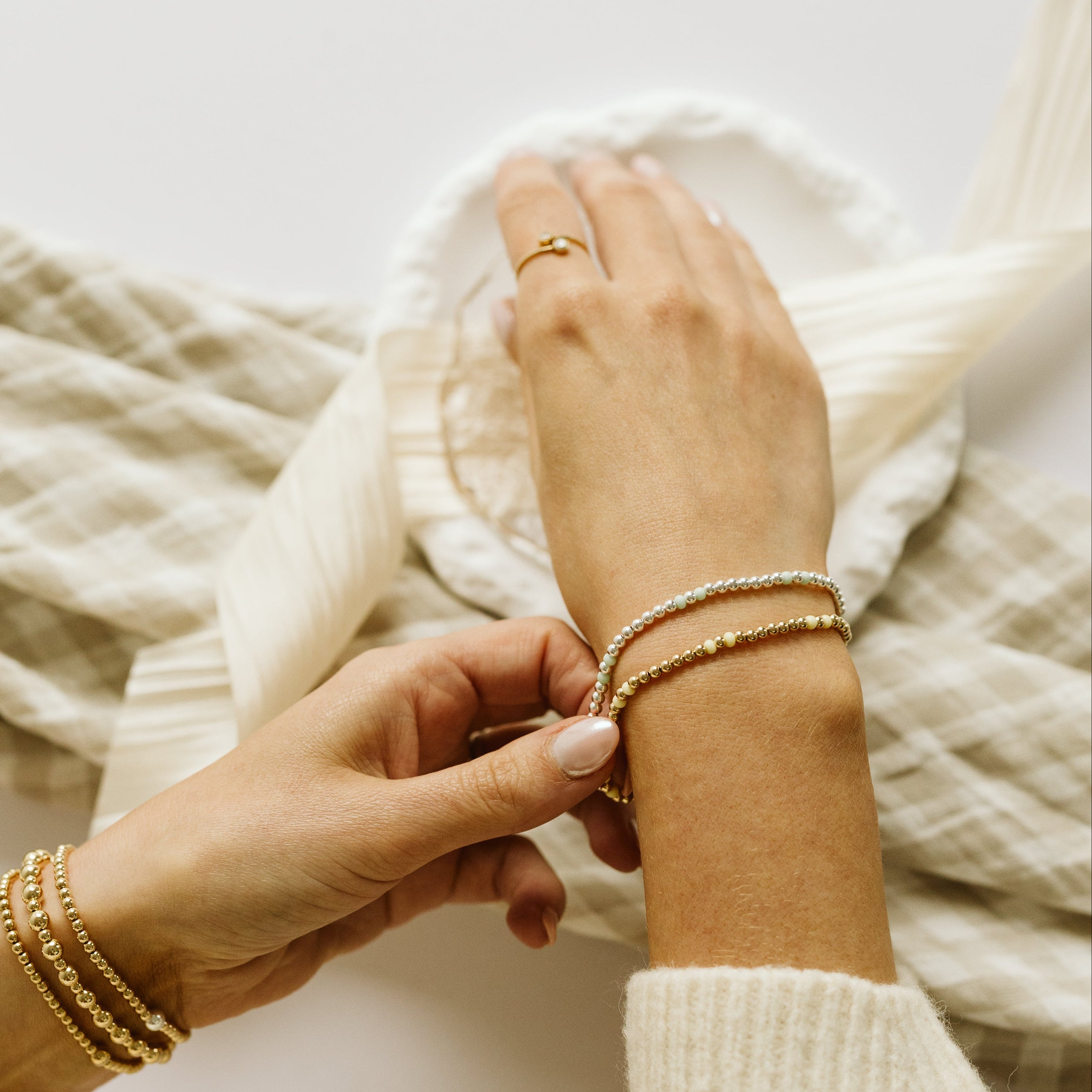 Gold and silver bracelets with yellow and green beads