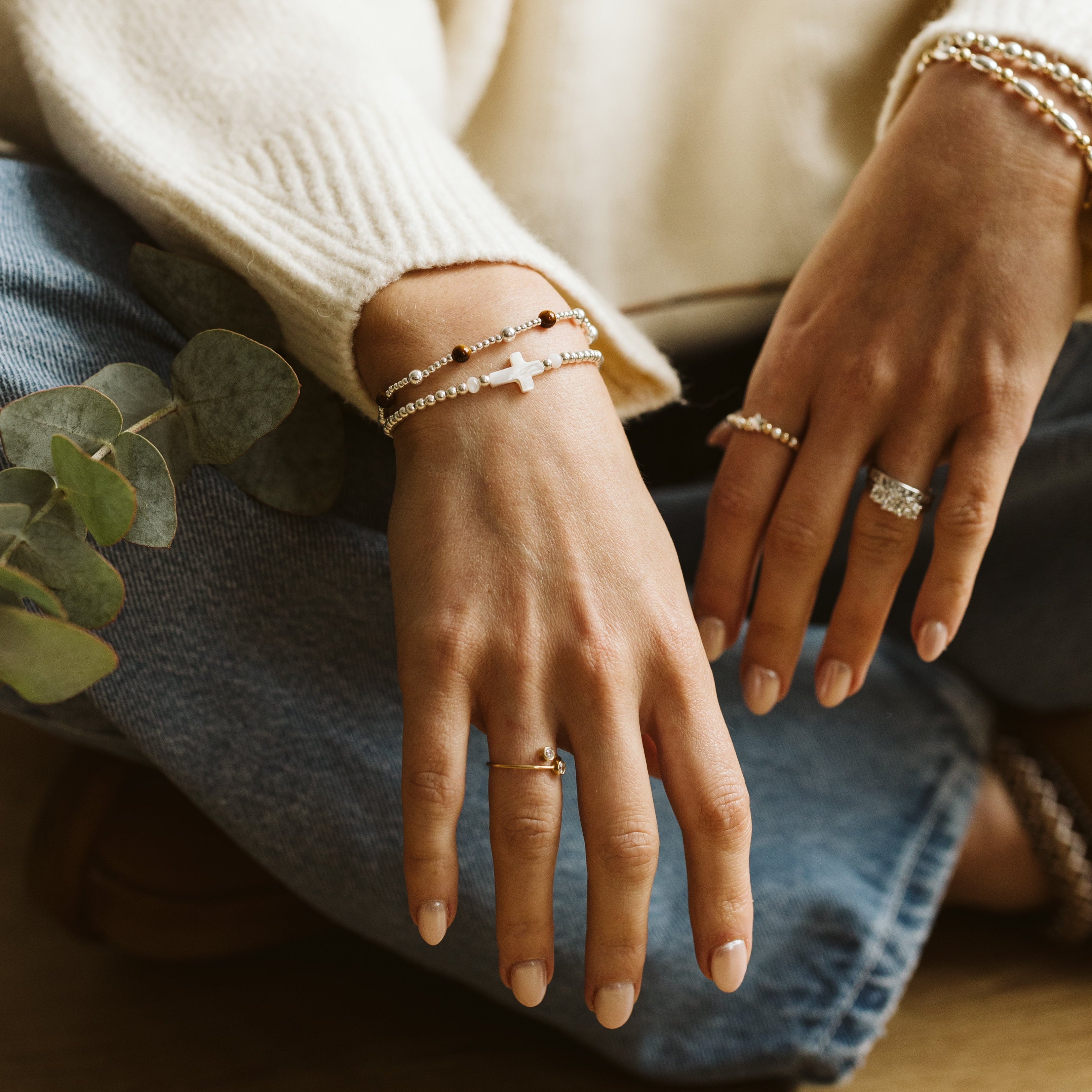 Cross bracelet with silver beads on woman's arm