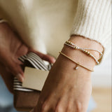 Close-up of a person's hands with jewelry holding a small box.